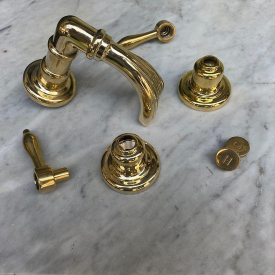 Unlacquered brass components of the Francone BT50 traditional deck-mounted bath tap faucet.