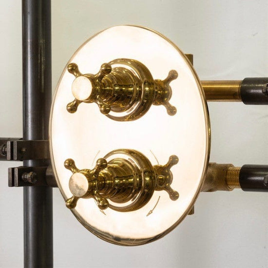 A detail of the Francone BTS33 concealed thermostatic shower with an oval unlacquered brass backplate and cross handles.