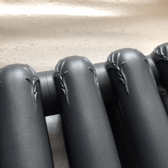 Ornate botanical relief on the Francone BTR12 solid brass heated towel rail with matt black radiator