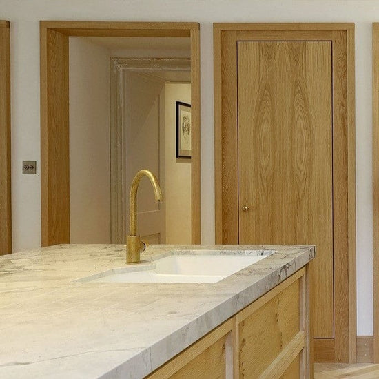 Francone BT14C tumbled brass kitchen mixer tap installed on a marble island countertop.