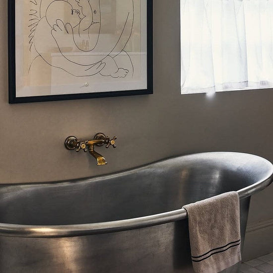 Traditional Italian Francone BT25 unlacquered brass wall-mounted bath filler faucet installed in a bathroom.