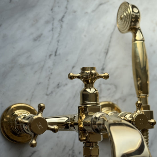 Detail of the handcrafted Francone BT25+ solid brass wall-mounted bath filler faucet and hand shower.