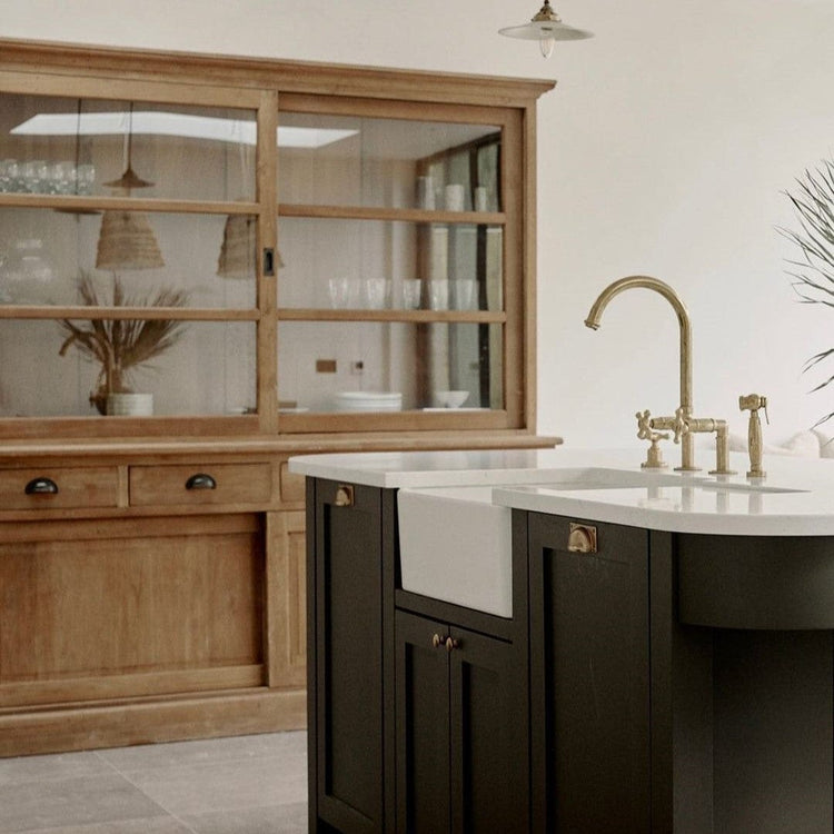A traditional Francone BT28Y unlacquered brass kitchen faucet with spray rinse, by Lauren Olivia Design.