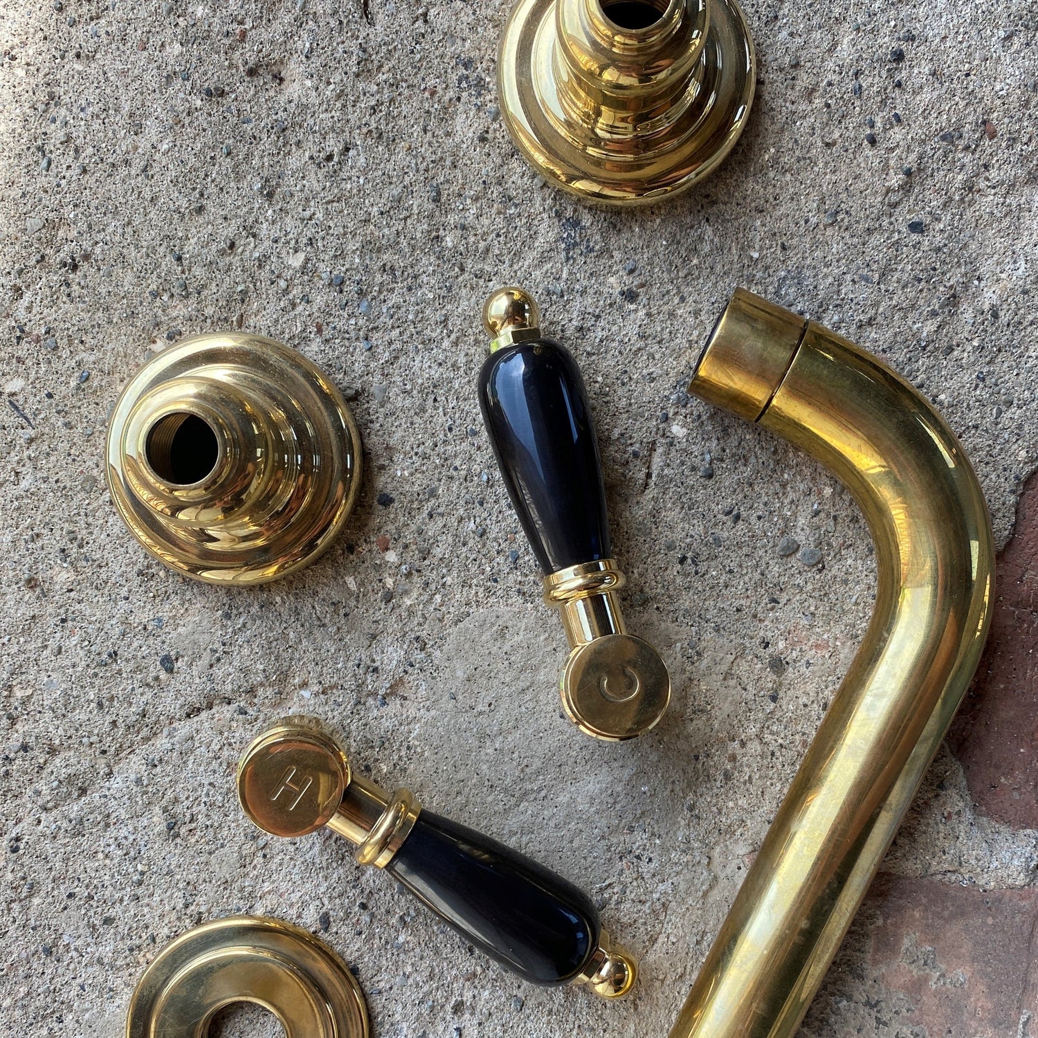 Francone BT34C traditional unlacquered brass wall mounted bathroom faucet with black ceramic lever handles.