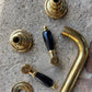 Francone BT34C traditional unlacquered brass wall mounted bathroom faucet with black ceramic lever handles.