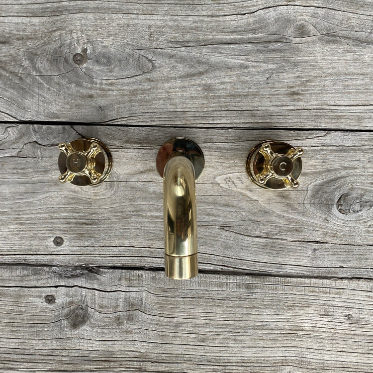 Francone BT34XL traditional unlacquered brass wall-mounted bathroom taps and faucet on a wood background.