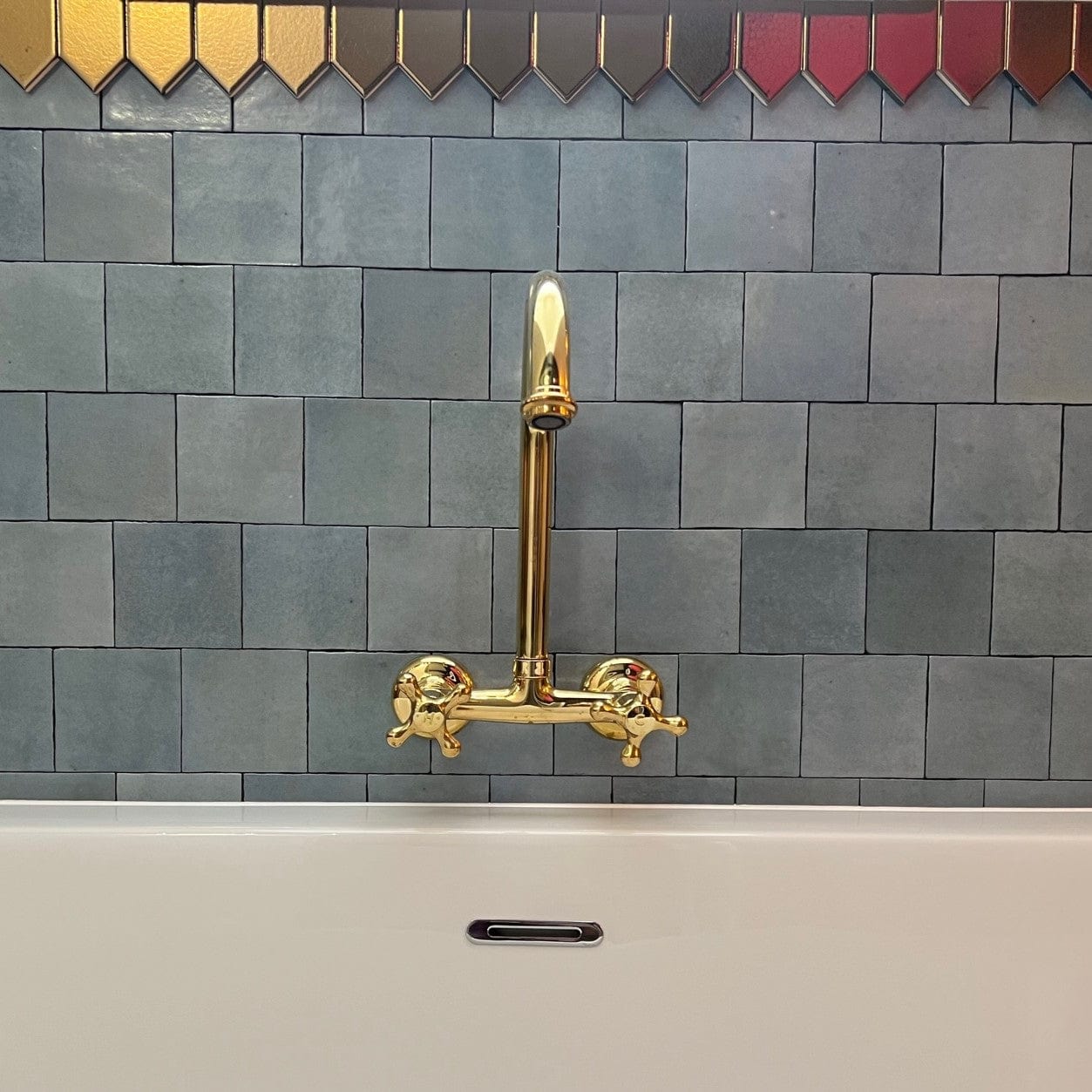 Francone BT35 traditional wall mounted bathroom faucet in unlacquered brass, installed above a bathtub by Jody Evans.