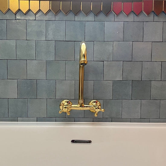 Francone BT35 traditional wall mounted bathroom faucet in unlacquered brass, installed above a bathtub by Jody Evans.