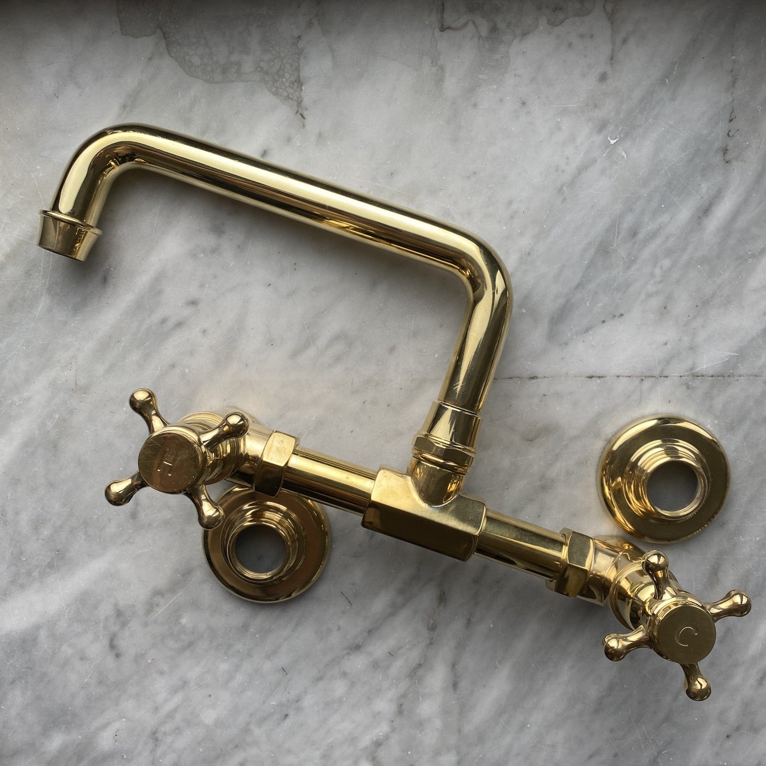 Traditional unlacquered brass wall-mounted bathroom faucet, the Francone BT40S bespoke tap on marble.