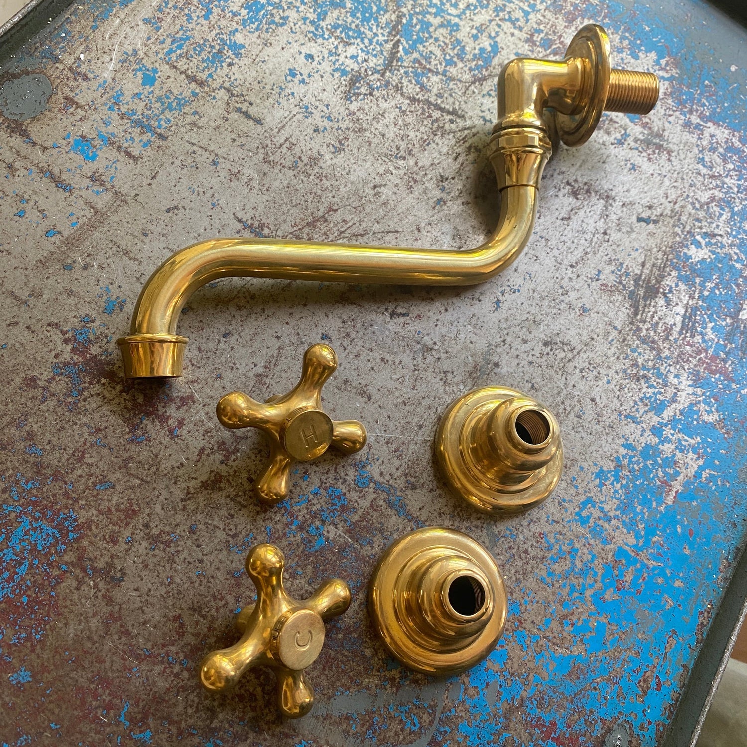 The disassembled parts of a traditional Francone BT43 wall-mounted bathroom faucet, crafted in unlacquered brass.