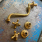The disassembled parts of a traditional Francone BT43 wall-mounted bathroom faucet, crafted in unlacquered brass.