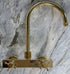 Francone BT49Q wall-mounted kitchen tap and faucet in unlacquered brass with a curve swivel spout and quadratic body.