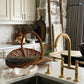 The Francone BT49R tall kitchen tap, a solid brass traditional faucet, installed in a rustic kitchen.