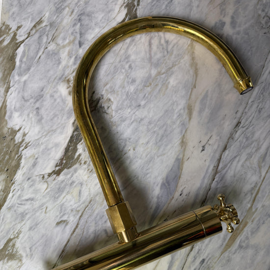 A detail of the solid brass Francone BT49T wall-mounted kitchen tap faucet on a marble surface.