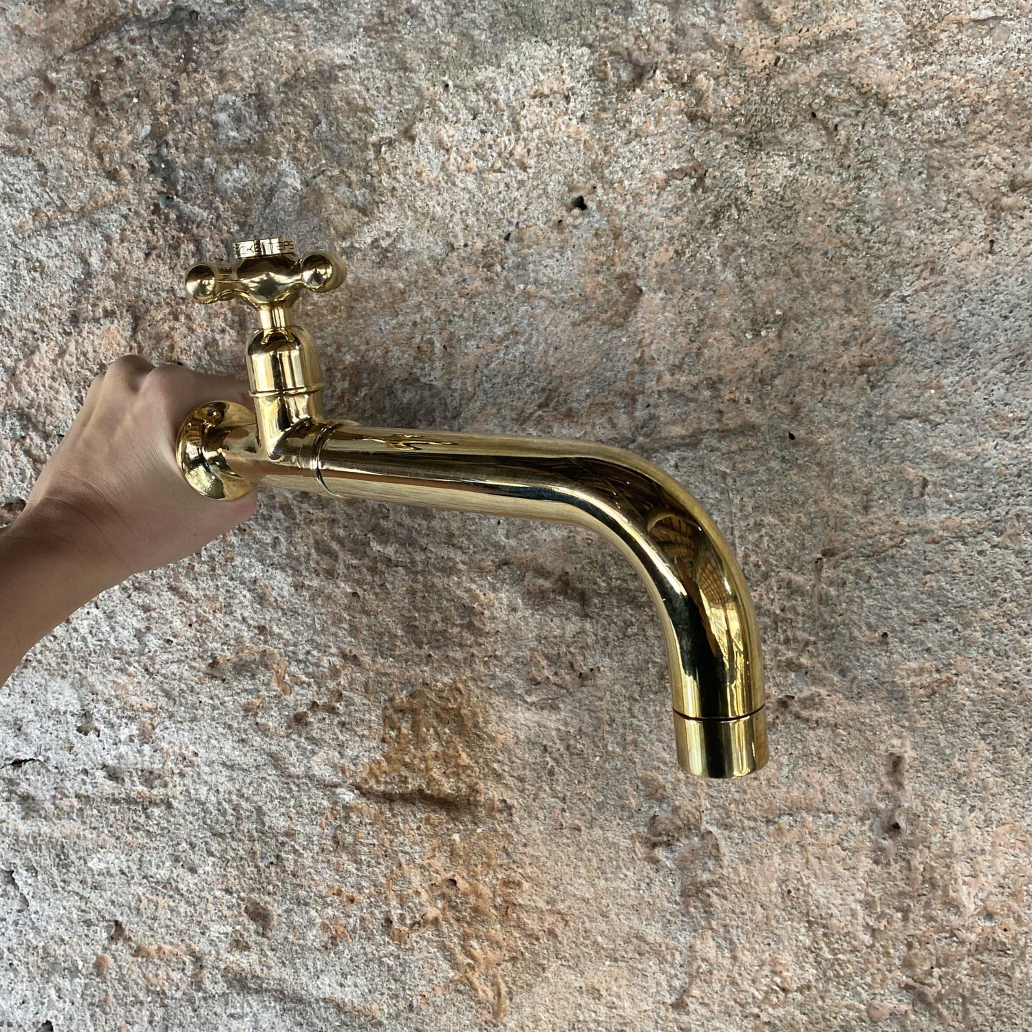 A hand holding the traditional Francone BT59T wall-mounted solid brass tap, a luxury bathroom faucet.
