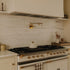 Traditional Francone BT6 unlacquered brass wall-mounted kitchen pot filler faucet installed over a range.