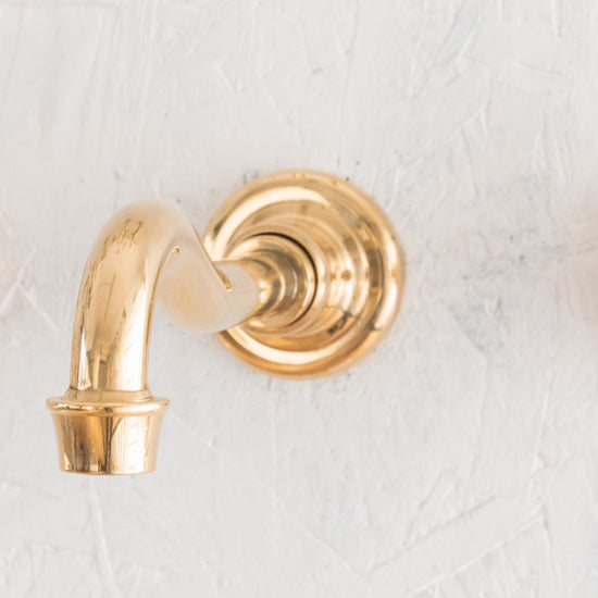 Detail of the Francone BT71 traditional wall-mounted bathroom spout faucet, in unlacquered brass.