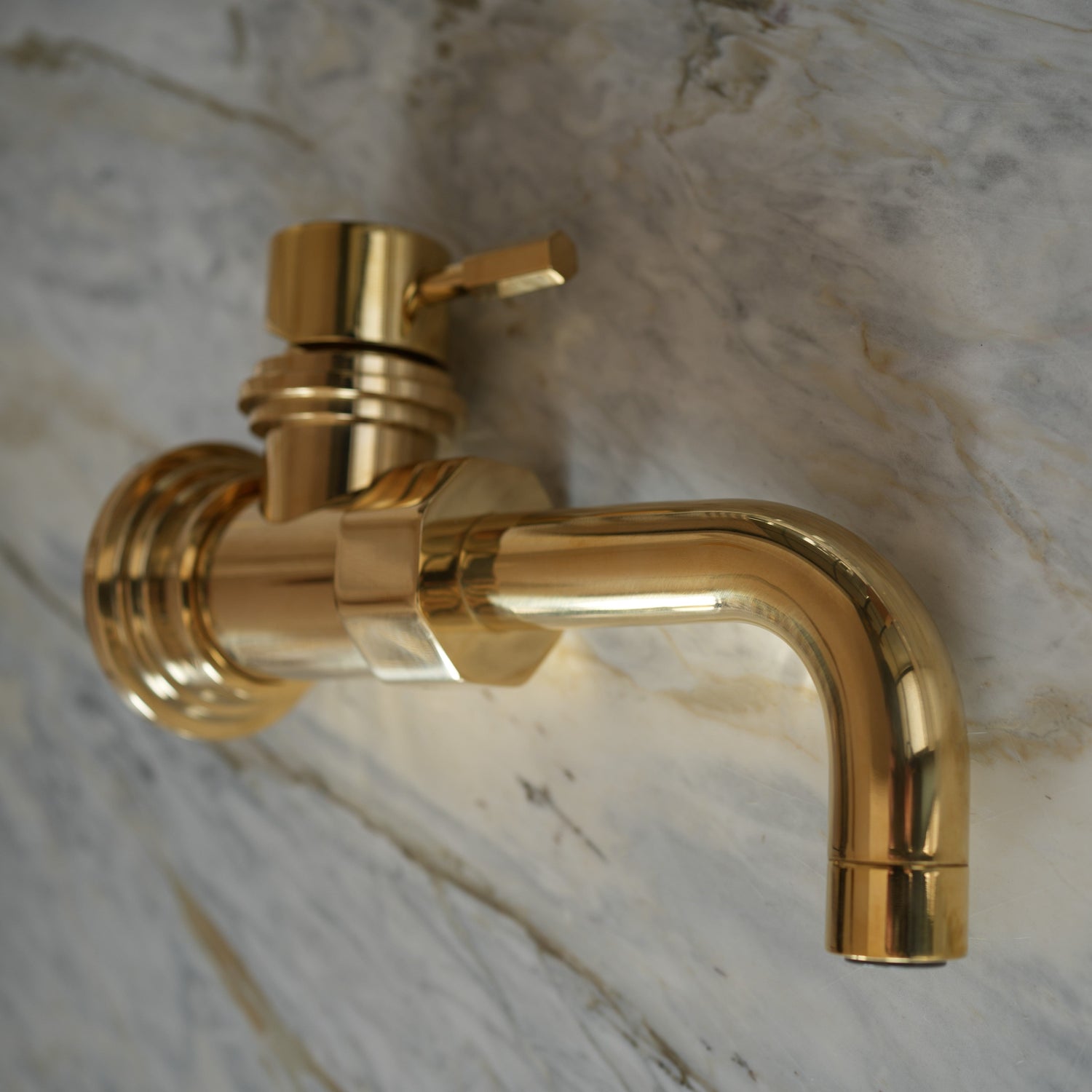 Francone BT7CW wall-mounted unlacquered brass mixer tap with a custom curved spout and handle, shown on marble.