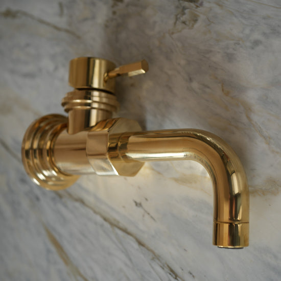 Francone BT7CW wall-mounted unlacquered brass mixer tap with a custom curved spout and handle, shown on marble.