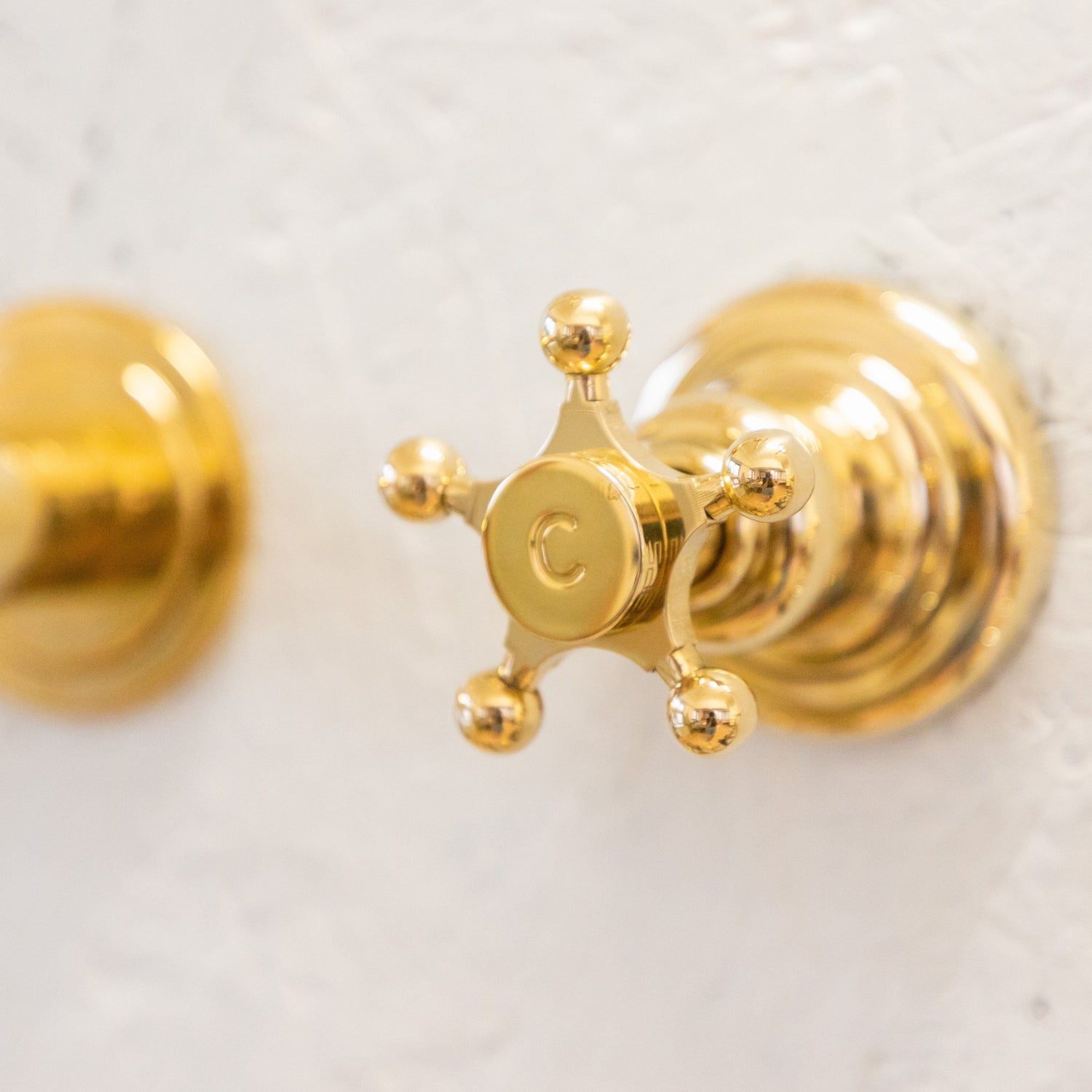 Detail of a traditional Italian unlacquered brass Francone BT82 bathroom faucet star handle.