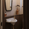 A traditional Francone BT97 unlacquered brass bathroom faucet installed on a small basin.