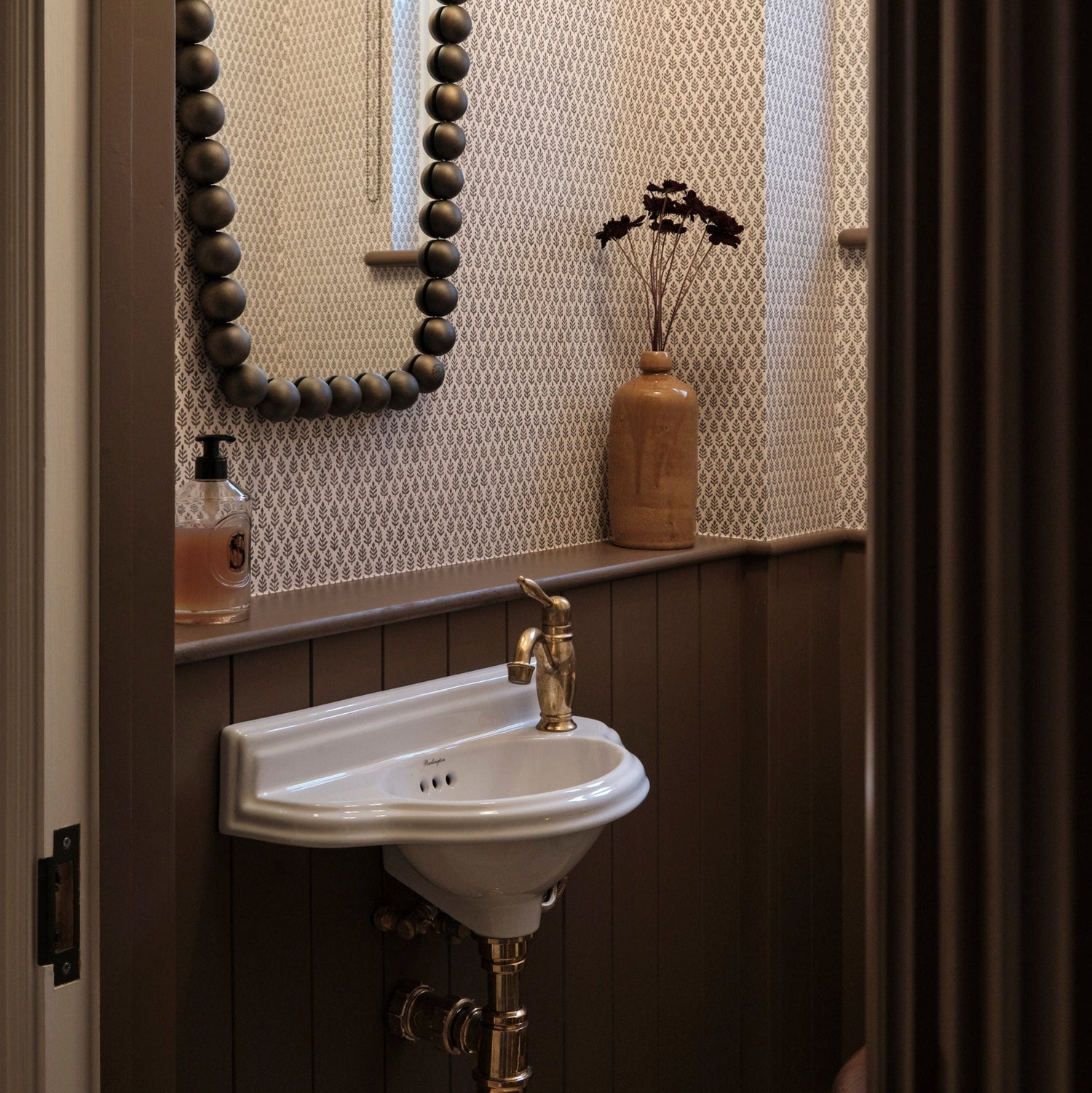 A traditional Francone BT97 unlacquered brass bathroom faucet installed on a small basin.