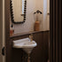 A traditional Francone BT97 unlacquered brass bathroom faucet installed on a small basin.