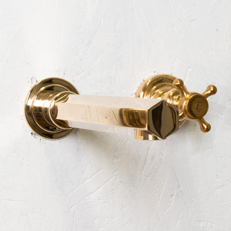 Detail of the Francone BT99 wall-mounted hexagonal faucet in unlacquered brass, handcrafted in Italy.