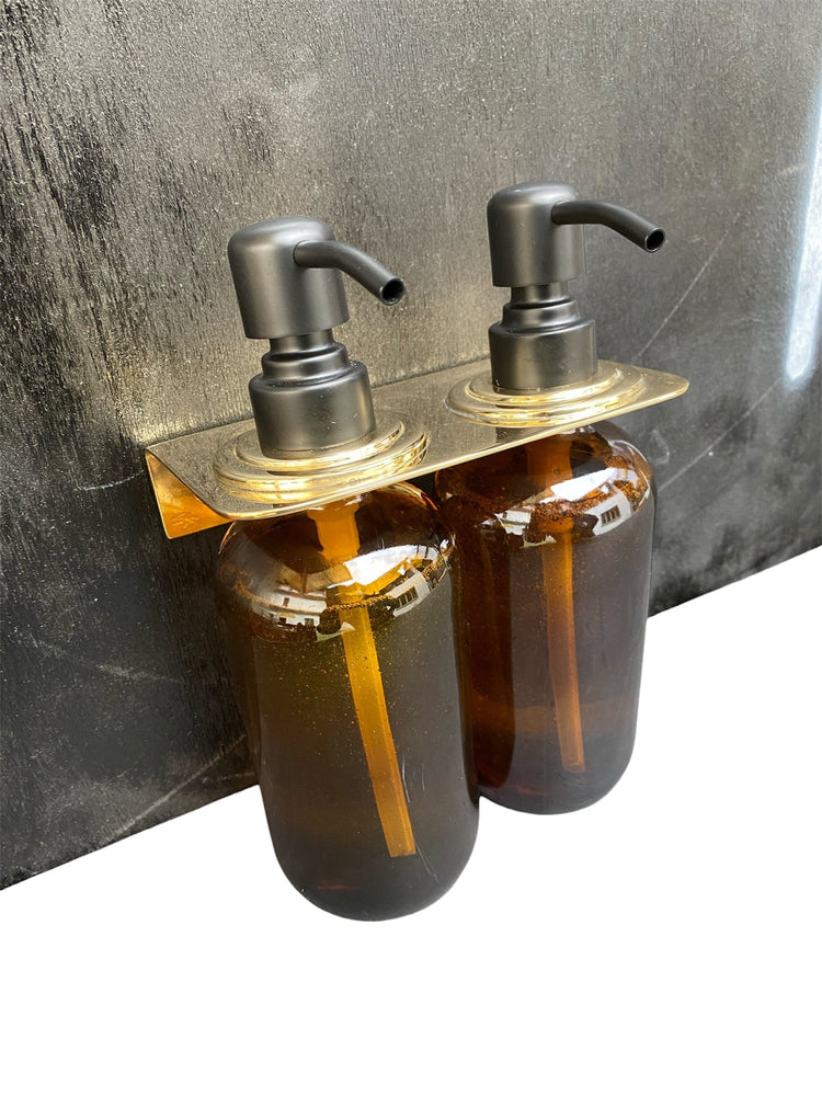 Francone BTA27 double soap bottle holder in solid brass, mounted with amber glass pump dispenser bottles.