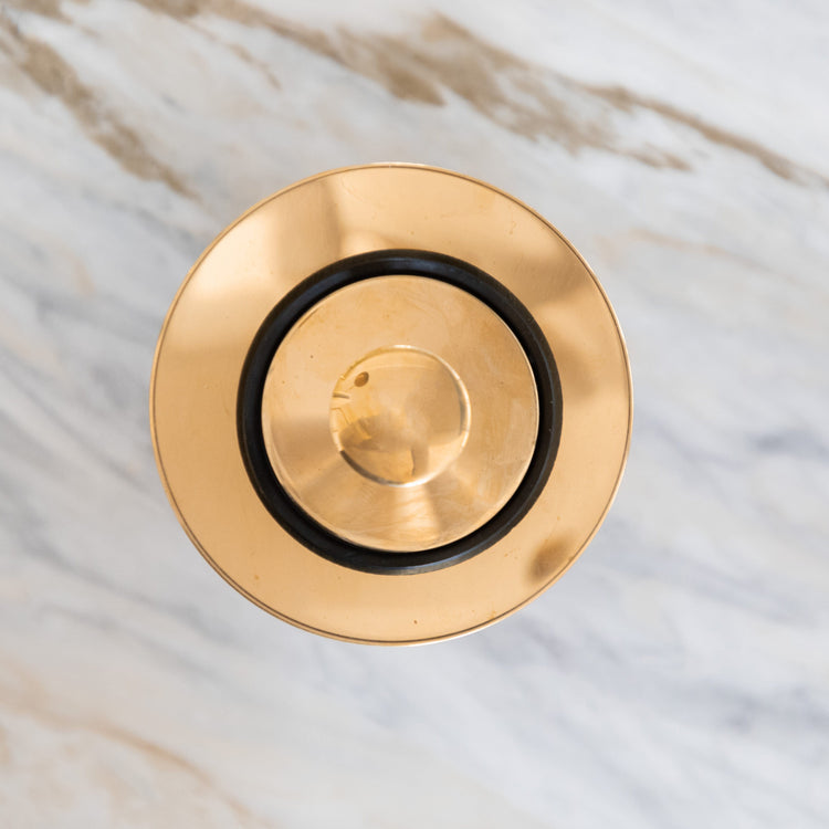 Traditional round Francone BTA2S basin waste plug in unlacquered brass, top-down view.