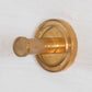 A Francone BTA35 round single robe hook in unlacquered brass, perfect for elegant bathroom accessories.