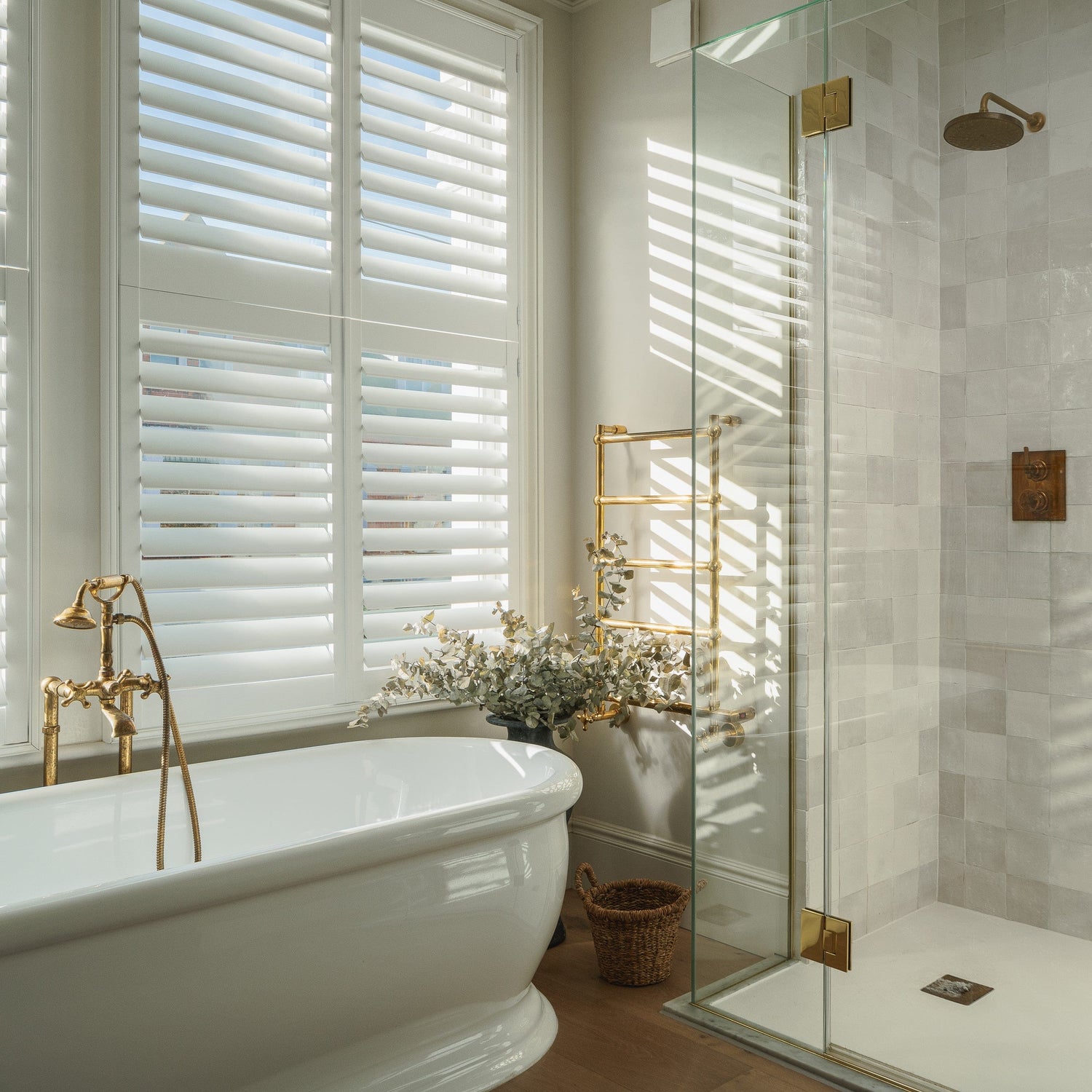 Francone BTR15 traditional plumbed heated towel rail in unlacquered brass, installed in a luxury bathroom.
