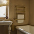 A classic Francone BTR19 five-bar unlacquered brass heated towel rail mounted on a bathroom wall.