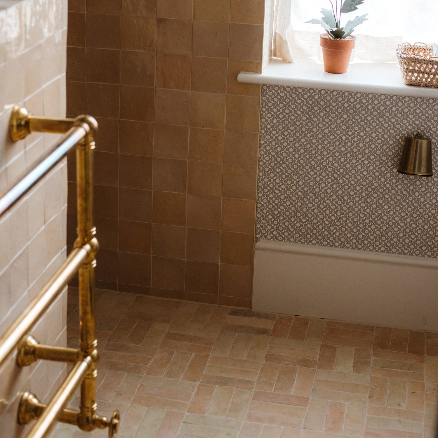 An unlacquered brass Francone BTR2 classic heated towel rail installed in a traditional bathroom.