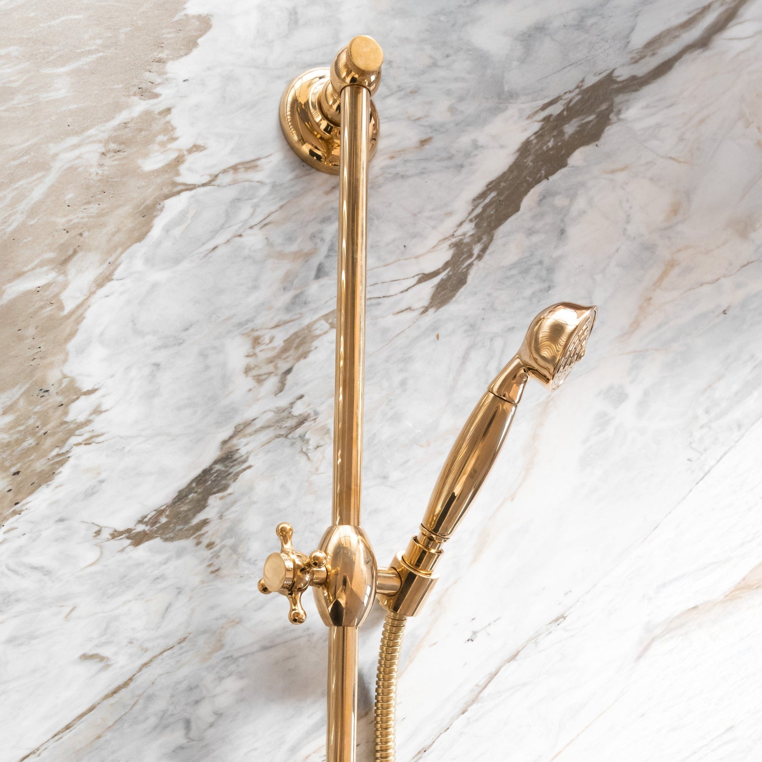 The Francone BTS21 unlacquered brass sliding rail handheld shower mounted on a marble wall.