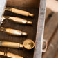 Bespoke solid brass Francone BTS26 traditional hand shower handles displayed in a rustic wooden drawer.