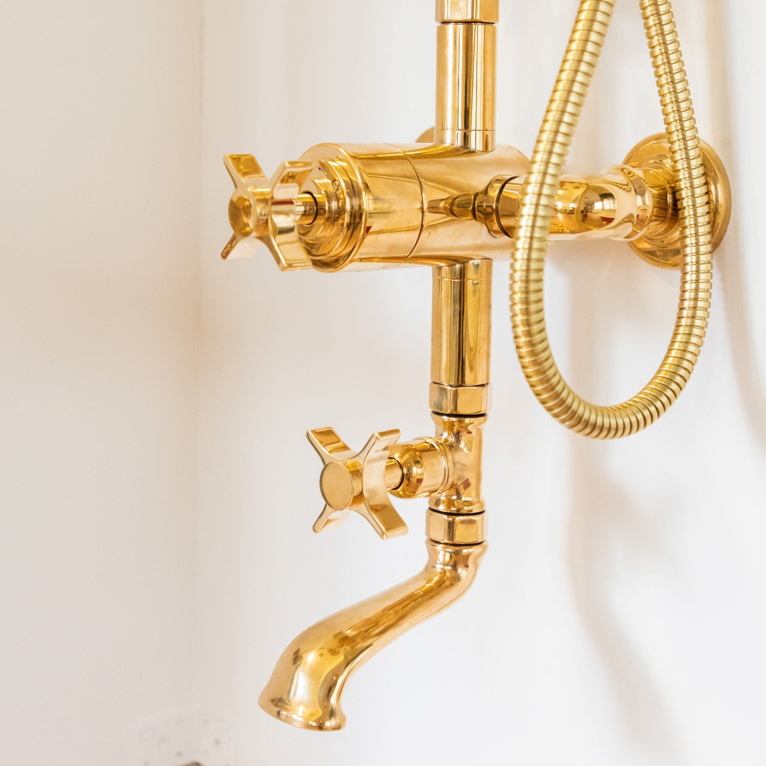 Detail of the gold plated brass Francone BTS3 thermostatic column shower and bath filler with crosshead handles.