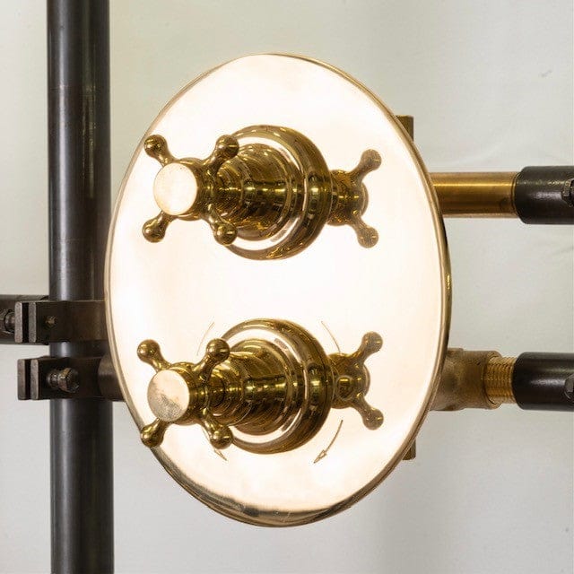 A detail of the Francone BTS33 concealed thermostatic shower with an oval unlacquered brass backplate and cross handles.