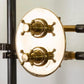 A detail of the Francone BTS33 concealed thermostatic shower with an oval unlacquered brass backplate and cross handles.