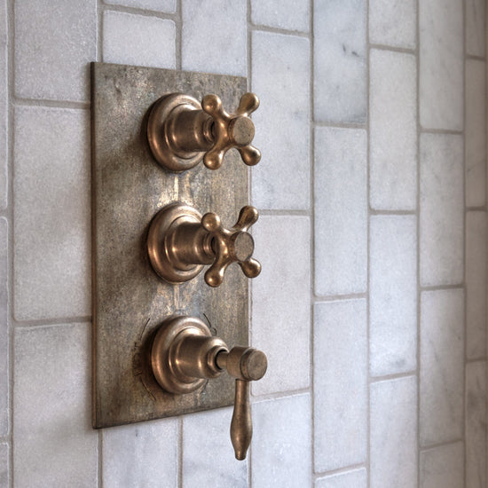 Francone BTS43 traditional thermostatic shower valve in tumbled brass, installed on marble tiles.