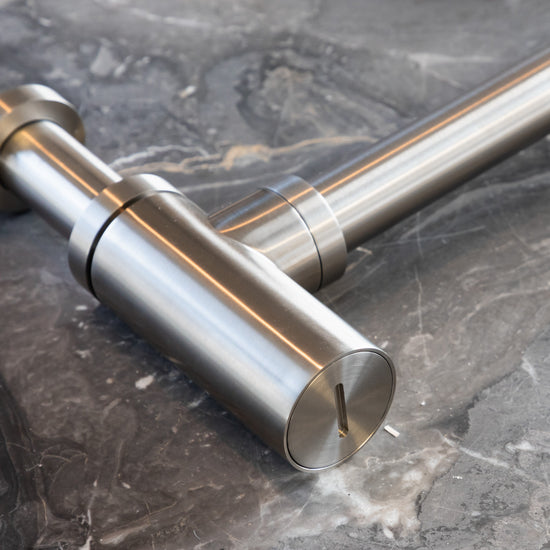 A close-up detail of the Francone SSA19 solid brass bottle trap on a grey marble background.