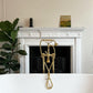 An installed Francone BT23F floor-mounted bath filler faucet in unlacquered brass in front of a fireplace, styled by Lorena Siminovich.
