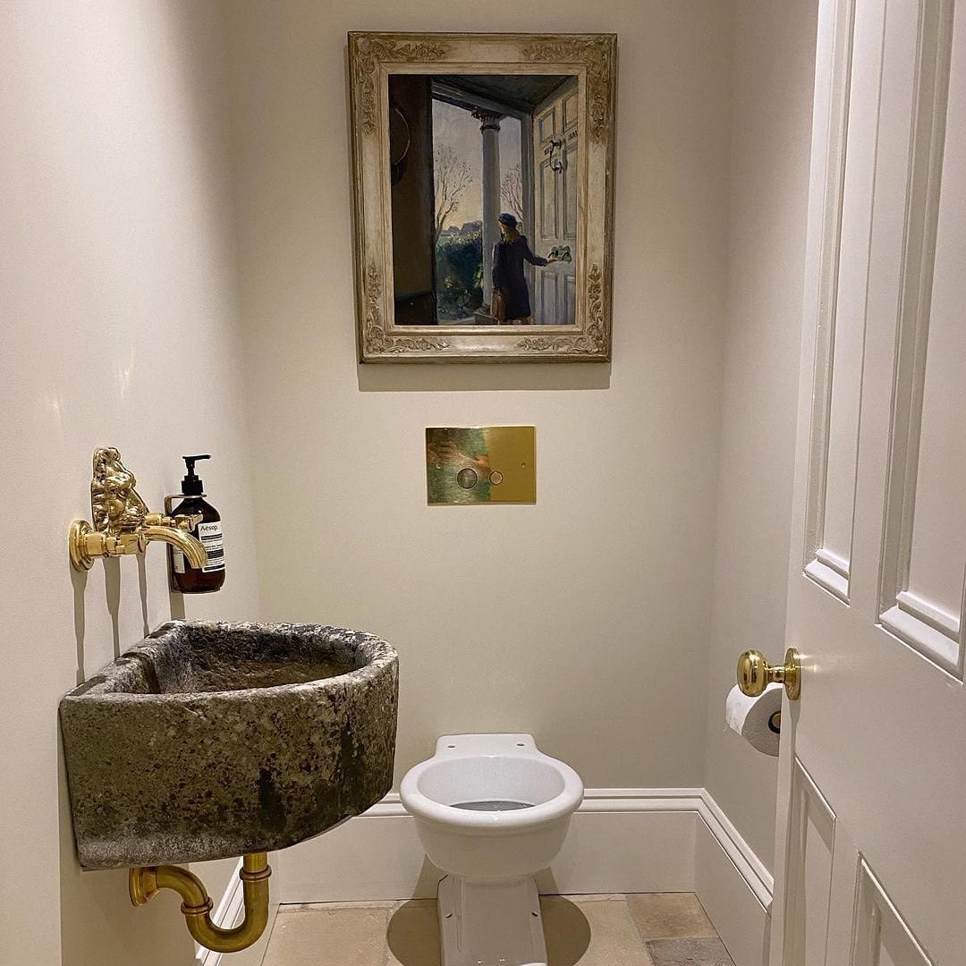 Traditional Francone BT39 unlacquered brass wall mounted faucet fitted in a bathroom above a stone basin.
