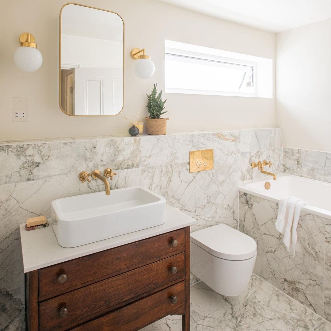The Francone BT70 wall-mounted brass tap, a traditional bathroom faucet, installed over a white washbasin.