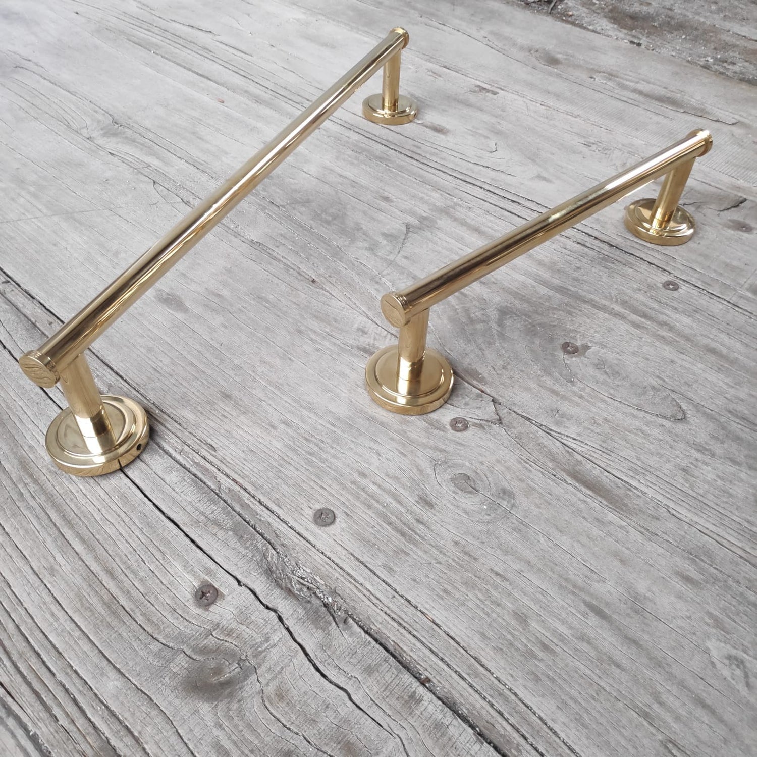 Two linear Francone BTA24 and BTA31 bathroom towel rails in polished unlacquered brass.