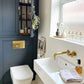 The Francone BTA6 unlacquered brass toilet dual flush plate installed in a contemporary bathroom by Simply Scandi Katie.