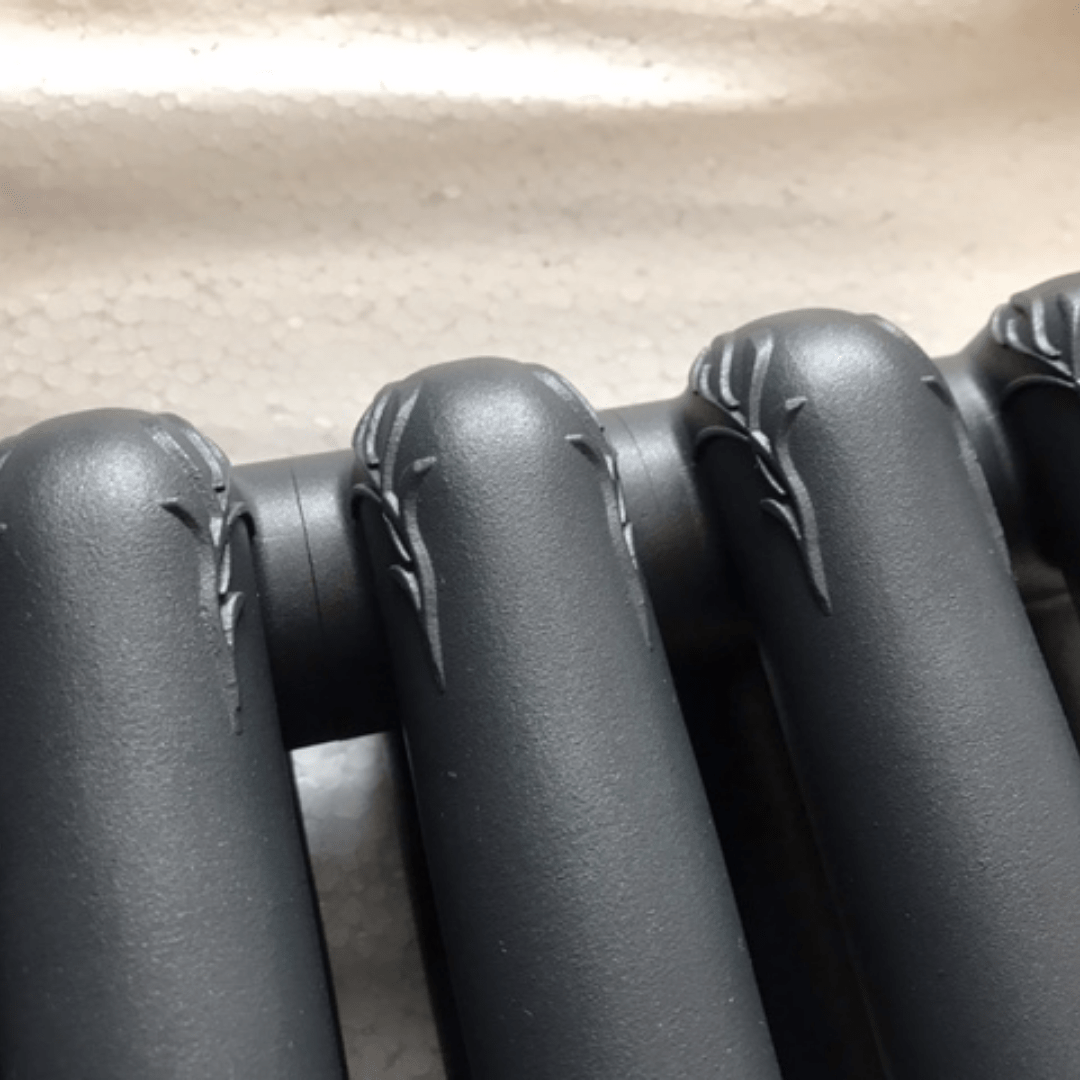 Ornate botanical relief on the Francone BTR12 solid brass heated towel rail with matt black radiator