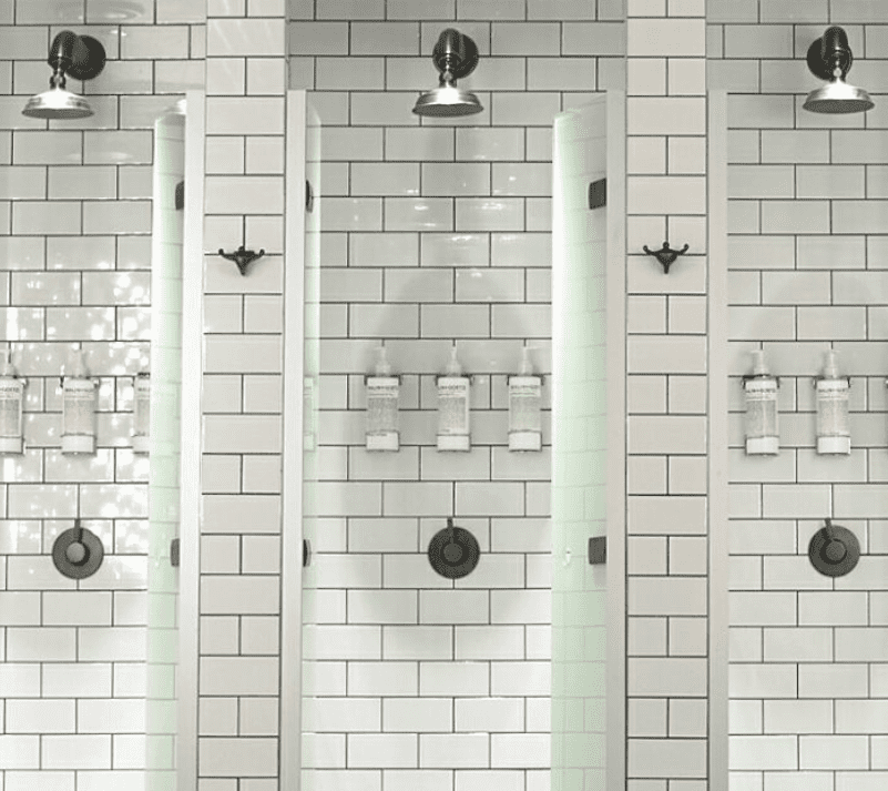 Francone BTS7 wall-mounted bespoke unlacquered brass shower sets  installed in a tiled bathroom.