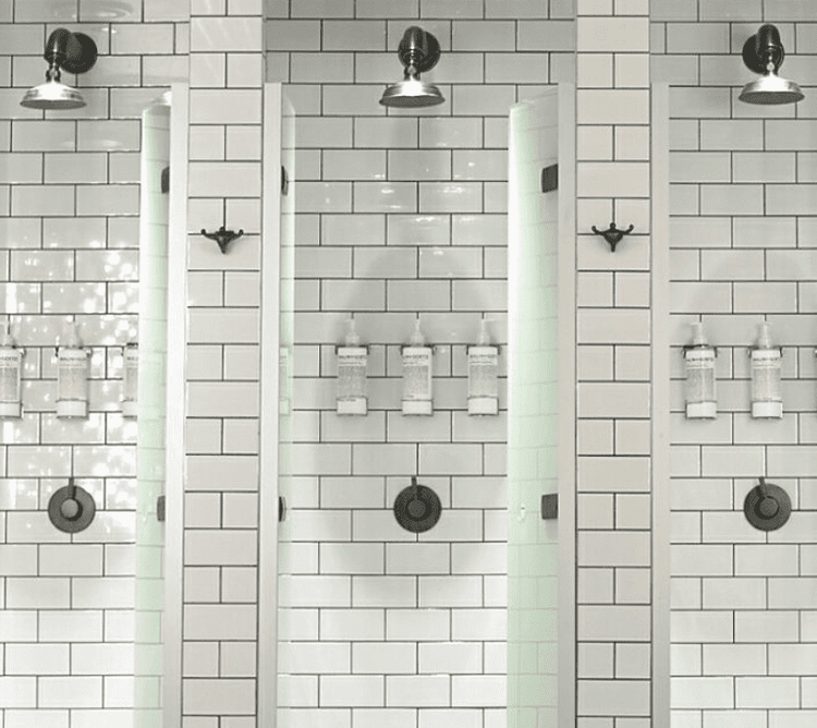 Francone BTS7 wall-mounted bespoke unlacquered brass shower sets  installed in a tiled bathroom.